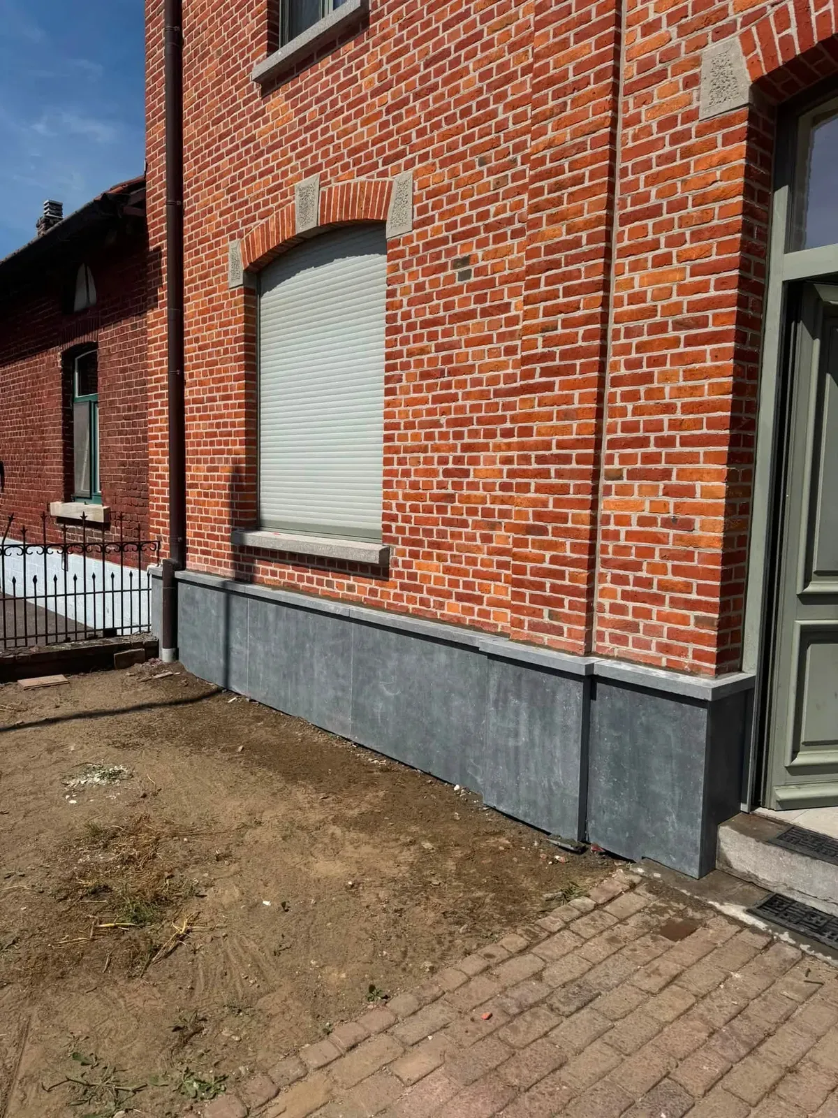 Gevelplint in arduin langs een bakstenen gevel