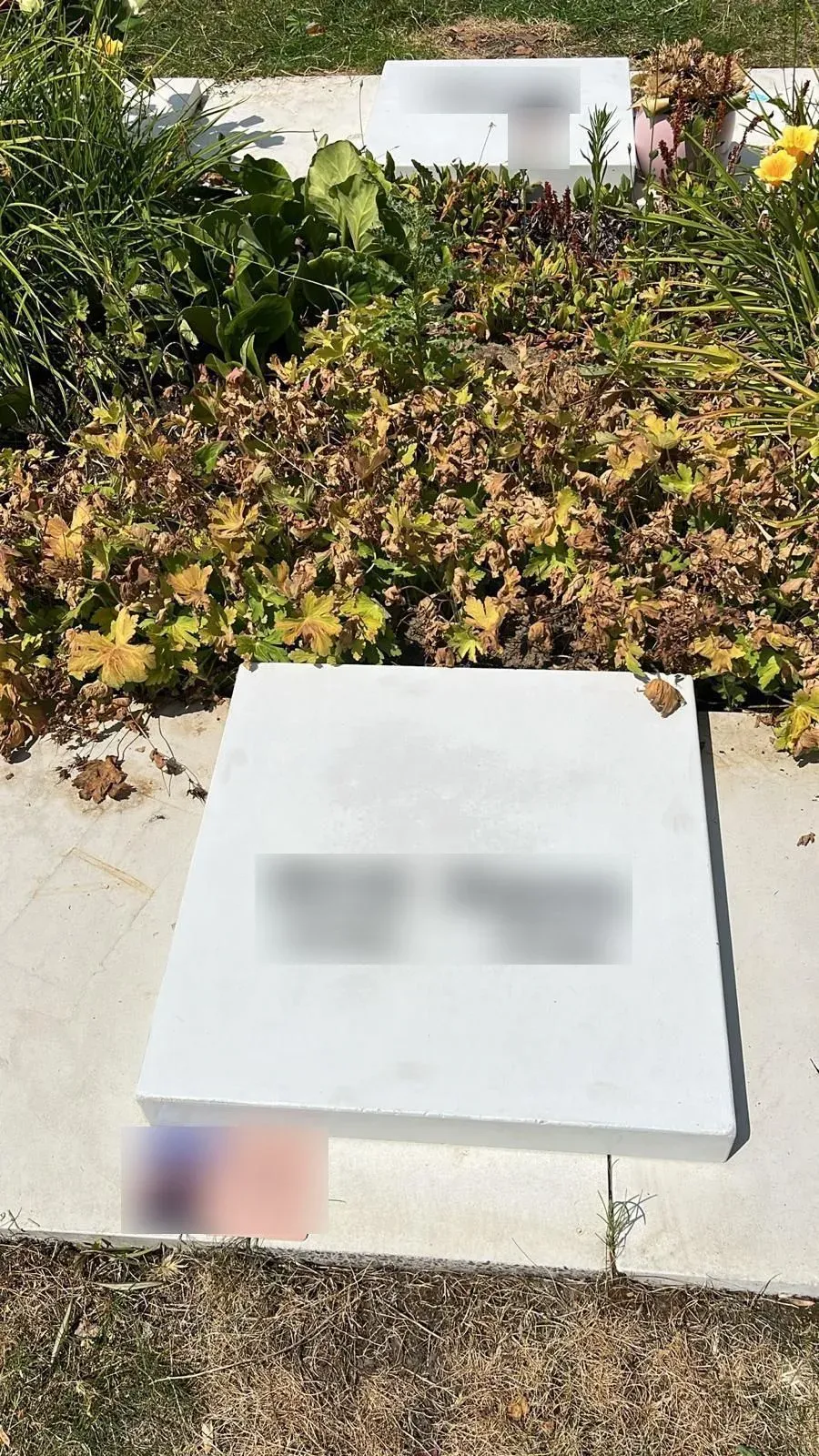 Gedenksteen van de vijvertuin in Genk met gefreesde opzetletters (namen onleesbaar gemaakt)